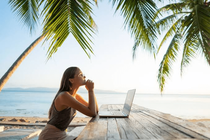 A female digtial nomad explring working from a bitch setting
