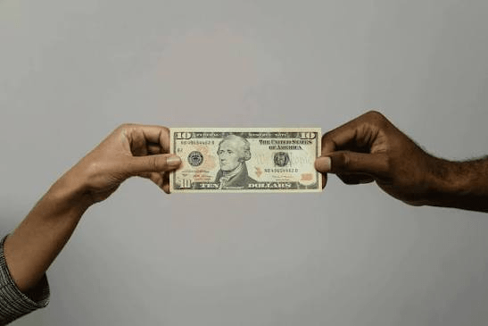 Two freelancers holding up a dollar note